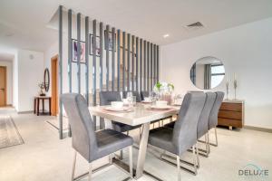 富查伊拉Luxury 4BR Villa with Assistant’s Room Al Dana Island, Fujairah by Deluxe Holiday Homes的一间带桌椅和镜子的用餐室