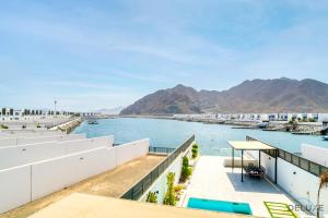 富查伊拉Luxury 4BR Villa with Assistant’s Room Al Dana Island, Fujairah by Deluxe Holiday Homes的从大楼的阳台上可欣赏到水景