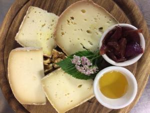 尚波吕克里富吉欧维埃欧克斯可雷司特酒店的桌上的一盘奶酪和其他食物