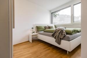 多恩比恩Smart Living Dornbirn的窗户客房内的一张床位