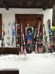 尚波吕克里富吉欧维埃欧克斯可雷司特酒店的一堆滑雪板和滑雪板在墙上排列