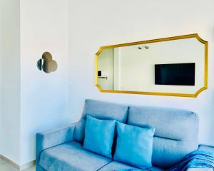 蓬塔穆赫雷斯Canaryislandshost l Cala的客厅配有蓝色沙发,设有镜子