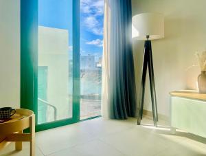 蓬塔穆赫雷斯Canaryislandshost l Cala的客房设有落地灯和大窗户。