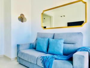 蓬塔穆赫雷斯Canaryislandshost l Cala的客厅配有蓝色沙发,设有镜子