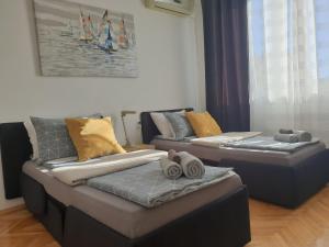 尼什Despot Apartmani Niš的客厅设有两张床,配有毛巾