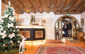 塞尔赖因山谷格里斯Bergsporthotel Antonie的一间房间里一棵圣诞树,一个女人拍了照片