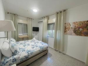 纳哈里亚海滩阿米哥酒店的一间卧室配有一张带蓝色和白色枕头的床