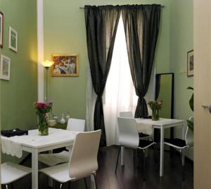 罗马亚历山大B&B酒店的用餐室配有2张桌子和白色椅子