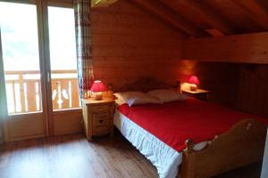 博福特Chalet ambiance montagne, 10 personnes, 4 chambres - CH15的一间卧室配有一张带红毯的床和两盏灯。