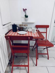 伦敦Cozy single room in Clapham的一张红色桌子,上面有两把椅子和盘子