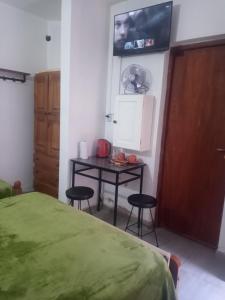 圣萨尔瓦多德朱Hostal Tía Dora的一间卧室配有一张床、一张桌子和一台电视。