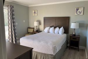 马可岛马科岛湖滨酒店的酒店客房配有带白色床单和枕头的床。