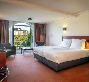 德科赫特克塞尔果岭酒店的酒店客房设有一张床和一个阳台。