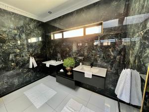 波罗瓜尼Forty 4 On Hoog的浴室设有两个水槽和黑色的墙壁