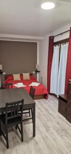 Gorla MinoreVilla Terzaghi的一间卧室配有红色的床、一张桌子和一张桌子。