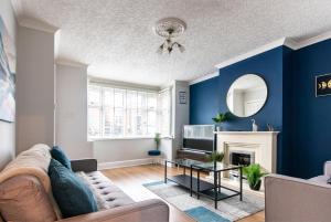 比斯顿2 Bedroom House in Chilwell - Perfect for Families and Business的客厅设有蓝色的墙壁、一张沙发和一张桌子