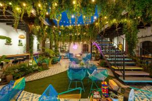 危地马拉安地瓜Adra Hostel的庭院配有蓝色的桌椅和灯光