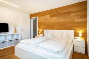劳特阿赫Ferienwohnung Lauterach的卧室配有白色的床和木墙