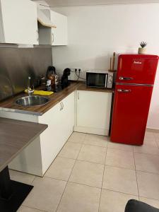 佩雷拉达apartament la cova的厨房配有红色冰箱和水槽