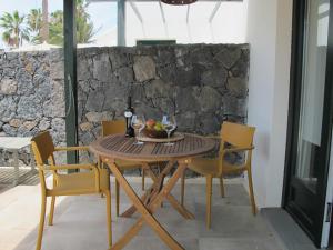 科斯塔特吉塞Bungalow GOA Pool view, Playa Roca residence sea front access - Free AC - Wifi的一张带椅子的木桌和一碗水果
