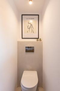 萨摩斯Chariclea Villa的一间带卫生间的浴室和墙上的照片