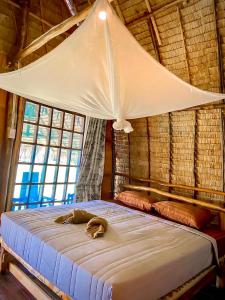高兰Lanta Marina Resort By Mam&Mod的一间卧室配有一张带天蓬和窗户的床