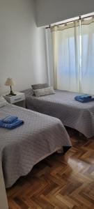 洛马斯-德萨莫拉Apartamento en el centro de Lomas的卧室设有两张床,铺有木地板