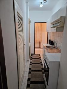 维也纳Central City Apartment的小厨房配有白色橱柜和水槽