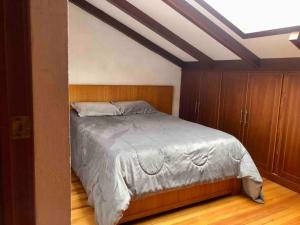 昆卡Cosita Linda - Departamento familiar 3 hab.的一间卧室配有一张床和木制橱柜