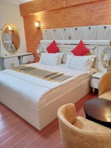 纳库鲁Gold Suite Hotel的一间卧室配有一张带红色枕头的大床
