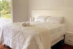 格拉玛多Blue House em Condomínio Fechado的卧室配有白色床和毛巾