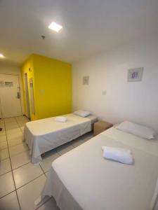 圣路易斯PRIME HOSPEDAGENS - Residencial Bellágio的一间设有两张床和黄色墙壁的客房