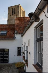 达默Het Oud Gemeentehuis-De Levensboom的一座白色的建筑,后面有钟楼