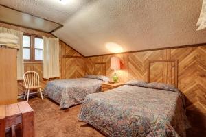 Iron RiverIron River Vacation Rental - Walk to Ski Brule!的一间卧室配有两张床和一张带台灯的桌子