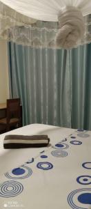 基加利PagersHome Suites - Classic Nyarutarama的一张带白色和蓝色床单及餐巾的床
