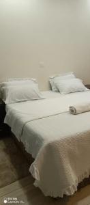 基加利PagersHome Suites - Classic Nyarutarama的白色的床、白色床单和枕头