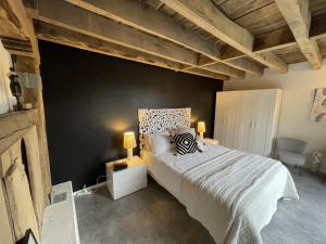 TrocheDordogne et Corrèze vacances BnB的一间卧室设有一张床和黑色的墙壁