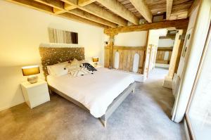TrocheDordogne et Corrèze vacances BnB的一间带一张大床的卧室,位于一个拥有木制天花板的房间