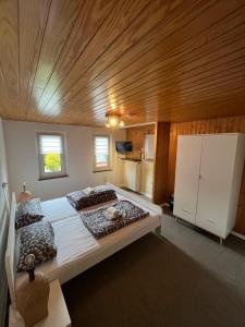 巴特恩豪森Ferienwohnung Süd的一间卧室设有一张带木制天花板的大床