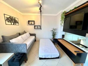 圣保罗Apto Flat no Morumbi com Vista Incrível !的带沙发和电视的客厅