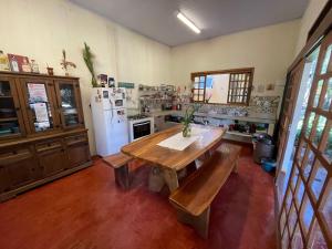 戈亚斯州上帕莱索Vila Amor - Charmosa e Central的厨房配有木桌和冰箱。
