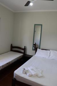 博拉塞亚Camping Pousada Ilha do Mel - Frente ao Mar的客房内的两张床和毛巾