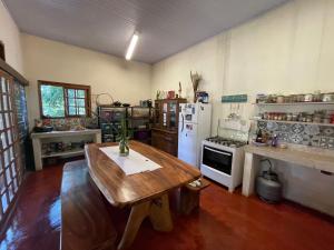 戈亚斯州上帕莱索Vila Amor - Charmosa e Central的厨房配有木桌和白色冰箱。