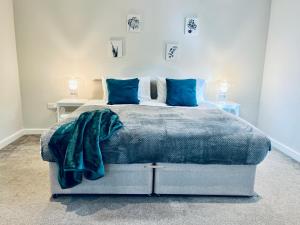 赫默尔亨普斯特德Absolutely Beautiful Hemel Hempstead 2-bedroom for 1-5 Guests - contractors welcome的一间卧室配有一张带蓝色枕头的大床