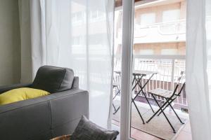 阿利坎特The Lucky Flats - Belando Quintana的带沙发和桌子的客厅以及阳台。