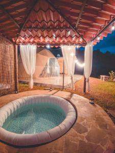 图里亚尔瓦Las Colinas Glamping的后院的热水浴池,带帐篷