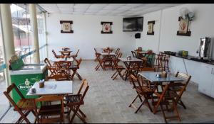 乌巴图巴Pousada Pescador的餐厅内带桌椅的房间