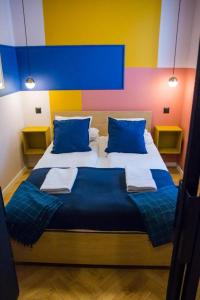 托伦HOLI的一间卧室配有一张带蓝色枕头的大床