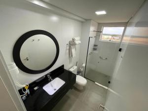 马林加Transamerica Executive Maringá的一间带镜子、水槽和淋浴的浴室