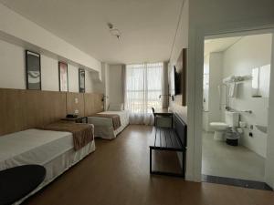 马林加Transamerica Executive Maringá的酒店客房带两张床和一间浴室